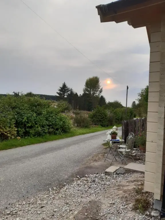 a road with a table and a chair on the side of a house at Springbank Cabin in Insch