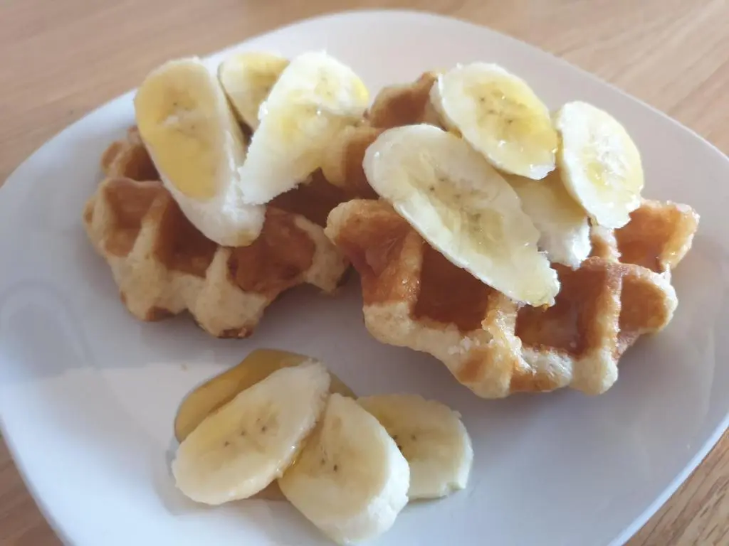 a white plate with waffles with bananas on it at Lorien House B&B in Fort Augustus