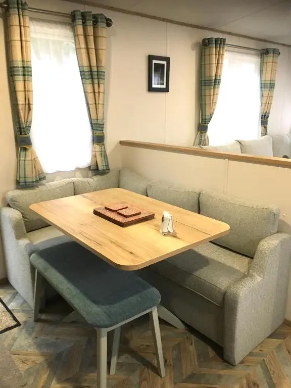 a table and chairs in a room with a couch at Bynack Lodge in Boat of Garten