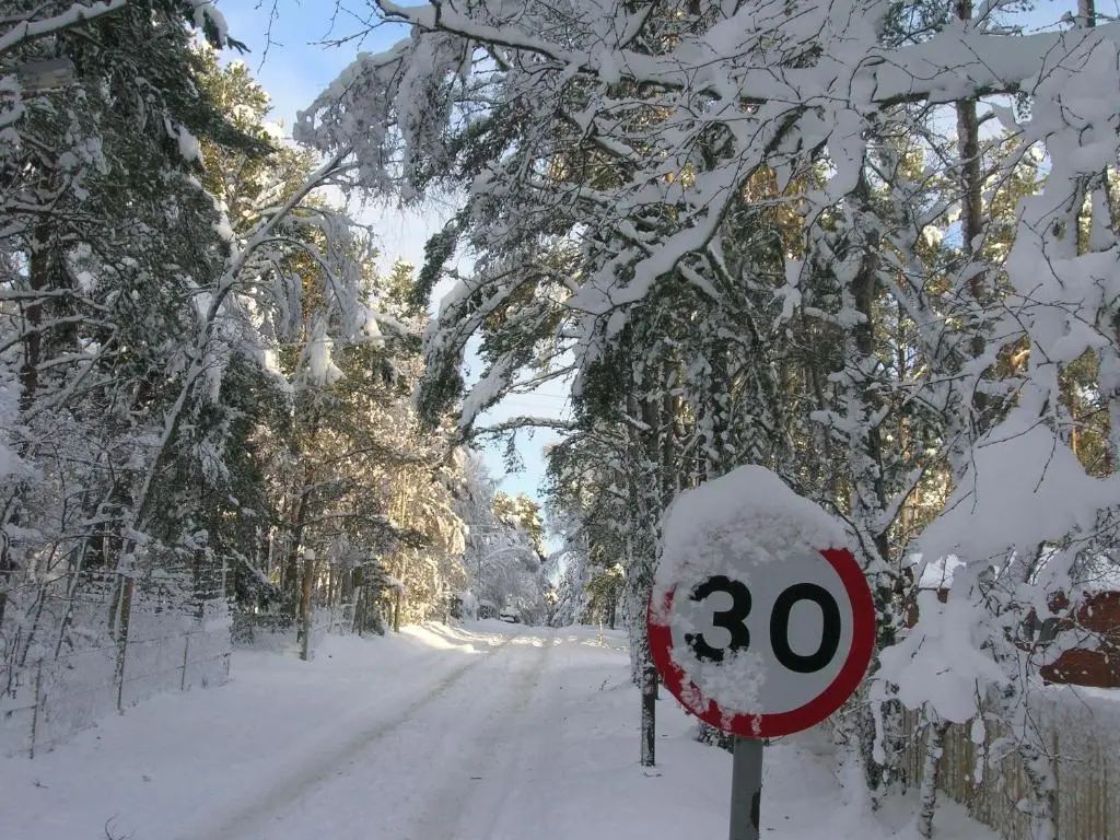 a stop sign covered in snow on a snowy road at Bynack Lodge in Boat of Garten
