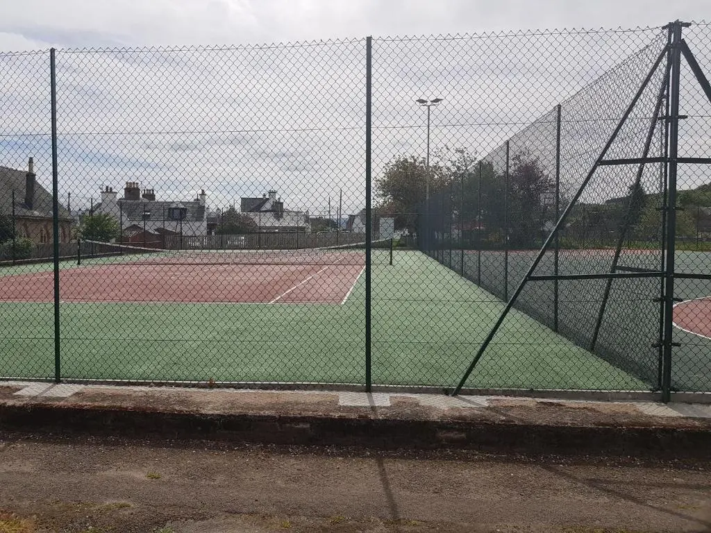a chain link fence on a tennis court at Black Isle Holiday Apartments in Avoch