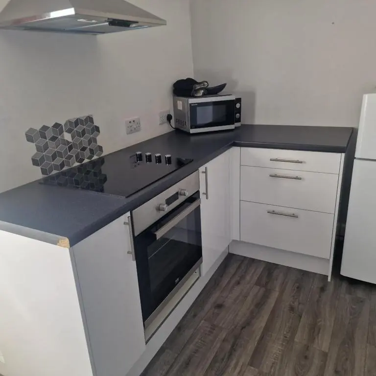 a kitchen with a stove and a microwave at Black Isle Holiday Apartments in Avoch