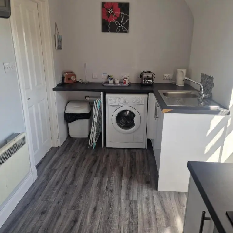 a kitchen with a washing machine and a sink at Black Isle Holiday Apartments in Avoch