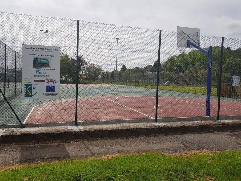 a tennis court with a fence on a tennis court at Black Isle Holiday Apartments in Avoch