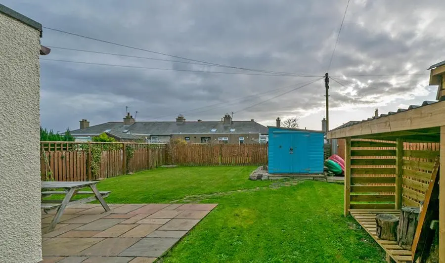 a yard with a blue shed and a fence at Cosy Cottage Close to East Beach, Shops, Restaurants and RAF base in Lossiemouth