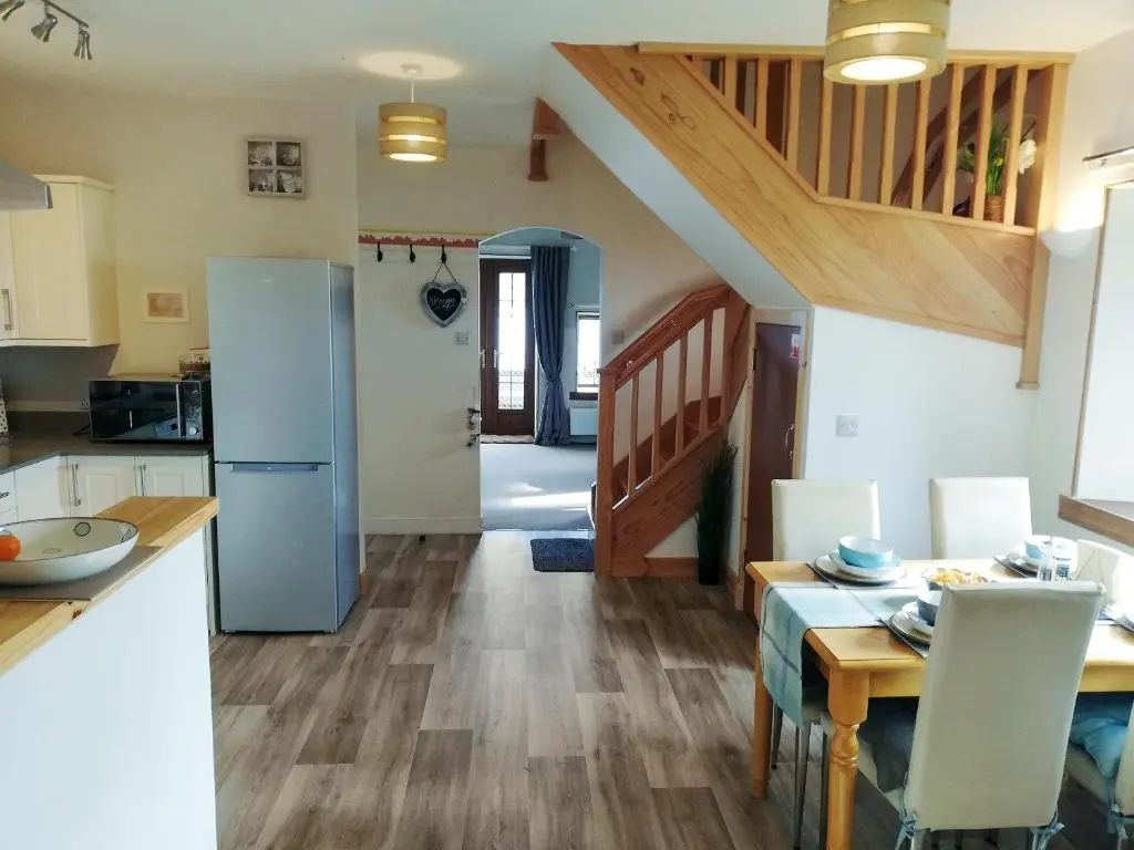 a kitchen and dining room with a staircase in a house at St Brighs in Dingwall