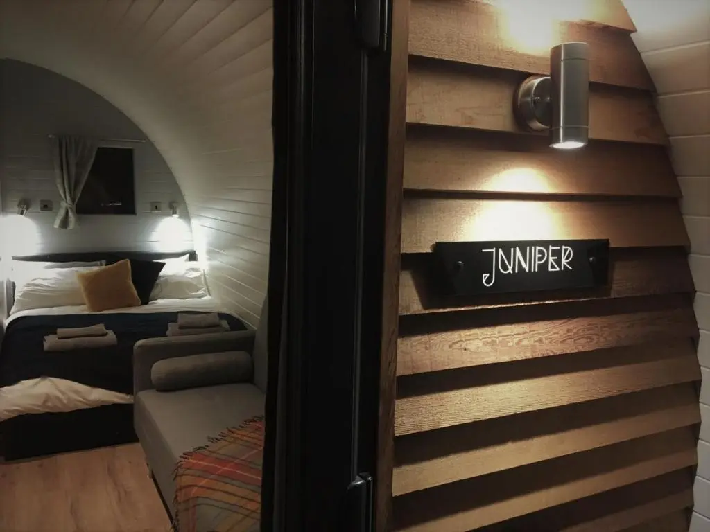 a room with two beds and a sign on the wall at Tomatin Glamping Pods in Inverness