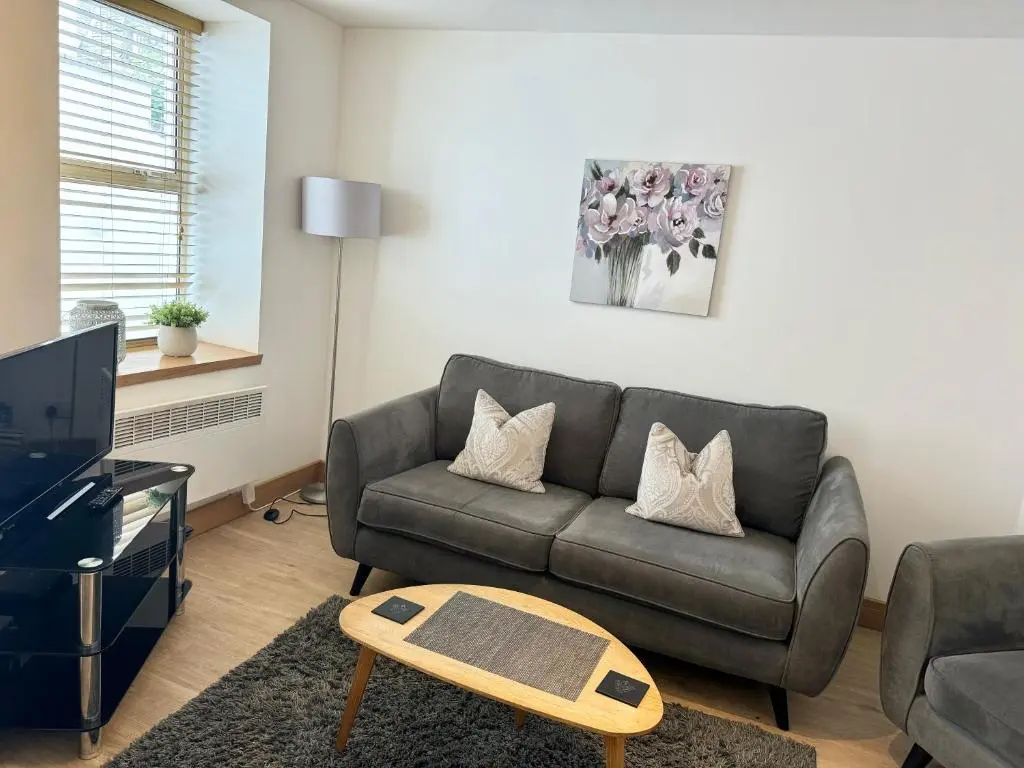 a living room with a couch and a tv at City Centre House in Inverness
