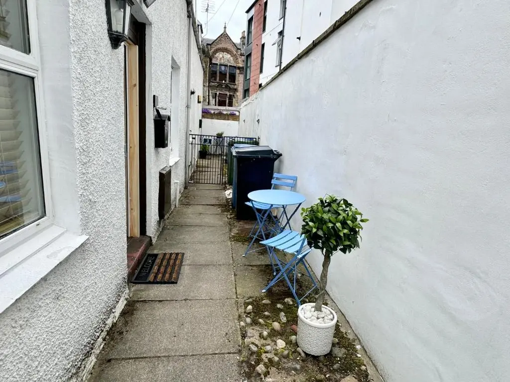 a small alley with a table and chairs next to a building at City Centre House in Inverness