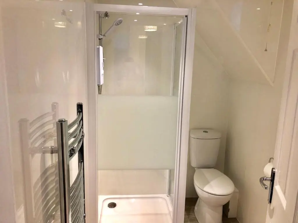 a small bathroom with a toilet and a shower at City Centre House in Inverness