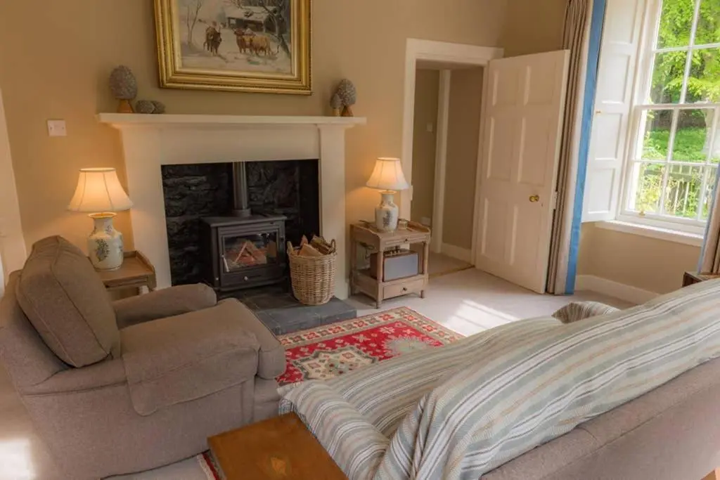 a living room with a couch and a fireplace at Quarry Gardens Lodge in Fochabers