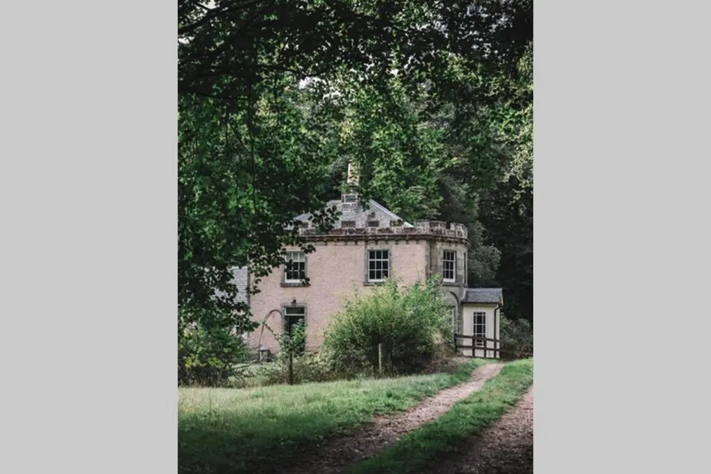 an old house in the middle of a dirt road at Quarry Gardens Lodge in Fochabers