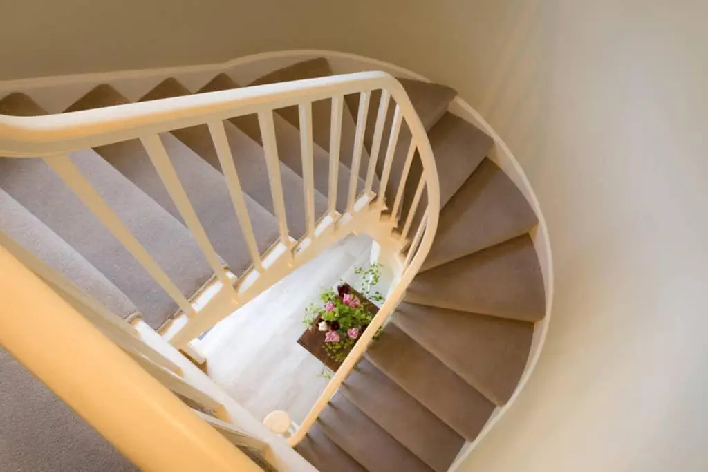 a spiral staircase with a pot of flowers on it at Quarry Gardens Lodge in Fochabers