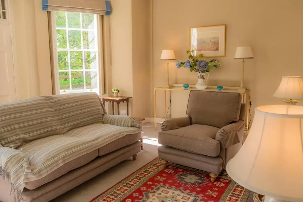 a living room with a couch and a chair at Quarry Gardens Lodge in Fochabers