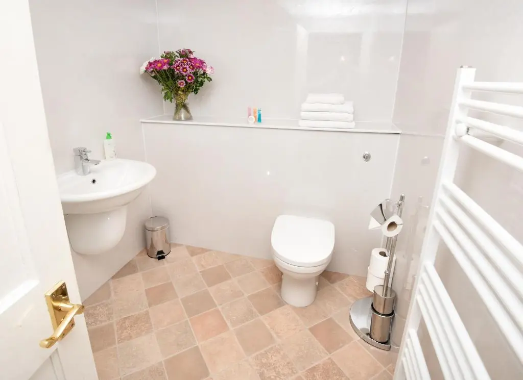 a white bathroom with a toilet and a sink at Acer Glen B&B in Inverness