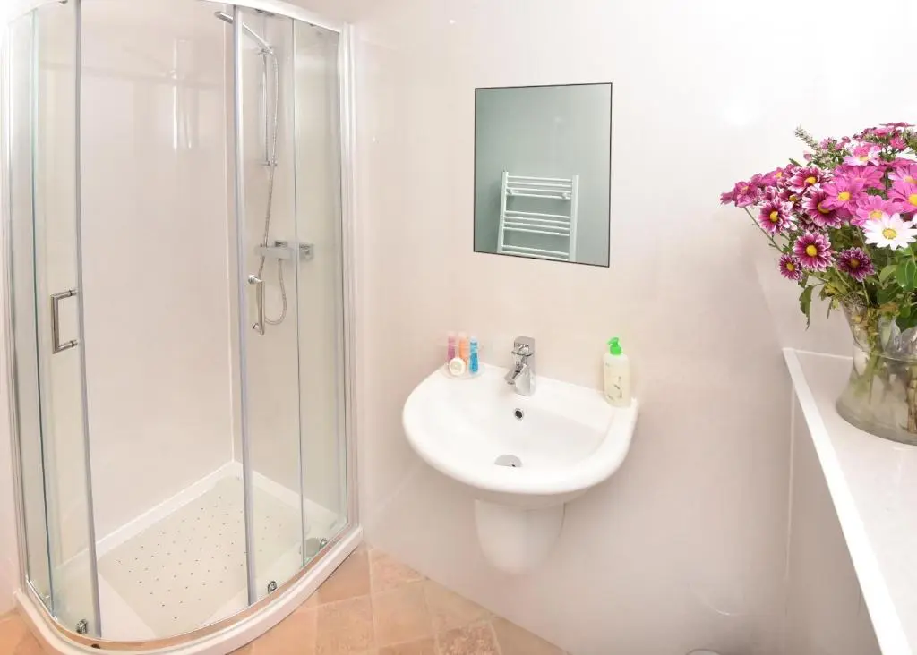 a white bathroom with a sink and a shower at Acer Glen B&B in Inverness