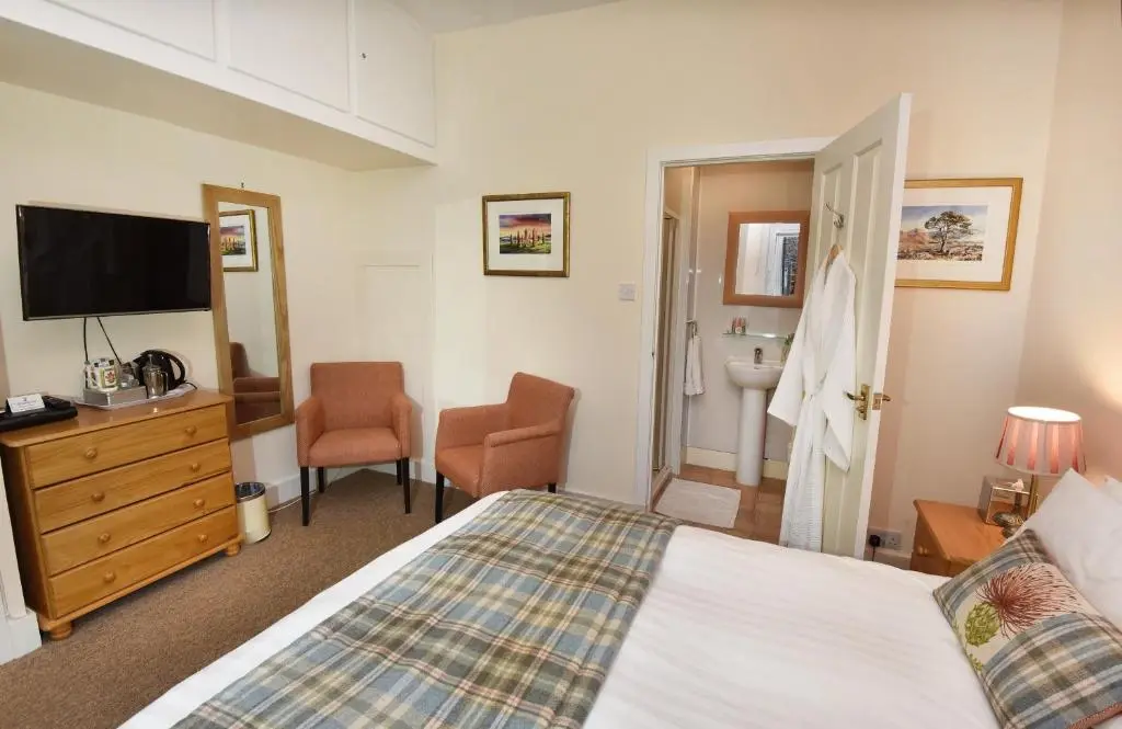 a bedroom with a bed and a flat screen tv at Acer Glen B&B in Inverness