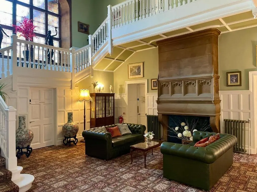 a living room with a couch and a fireplace at Rossal House Apartments in Inverness
