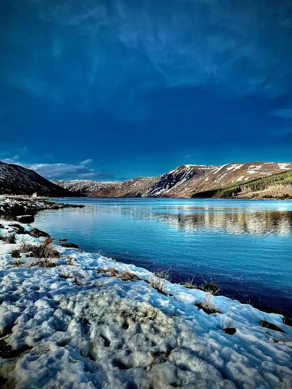 a body of water with snow on the shore at Rossal House Apartments in Inverness