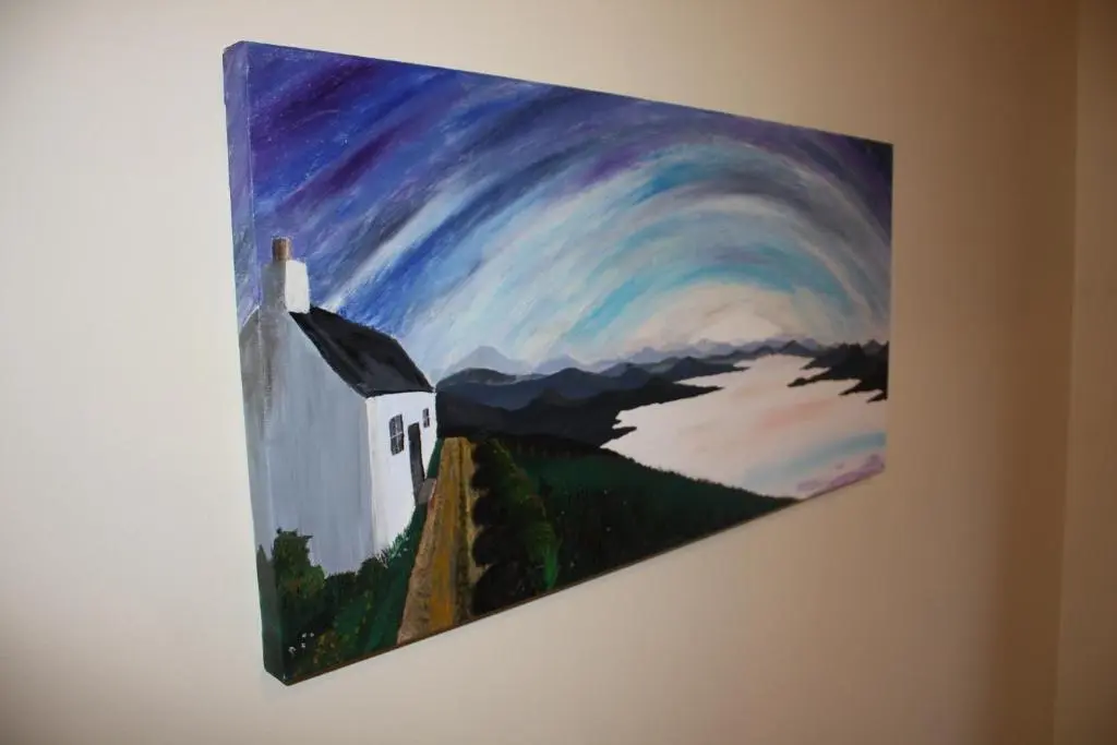 a painting of a church hanging on a wall at Loch Ness Balcony Apartment in Drumnadrochit