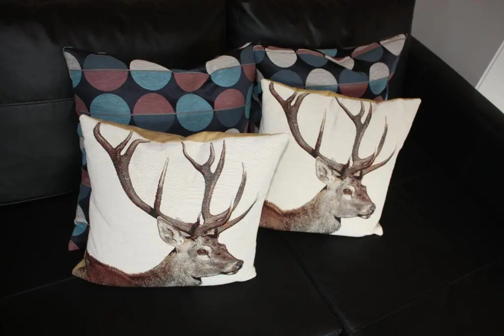 a couple of pillows with deer heads on them at Loch Ness Balcony Apartment in Drumnadrochit