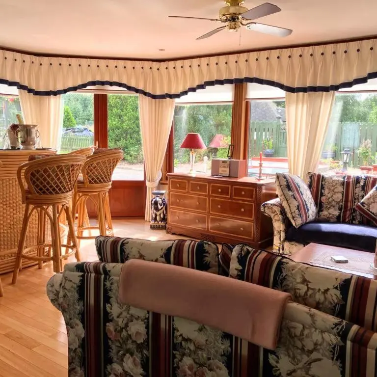 a living room with a couch and a table at Stunning 7 Bedroom Bungalow Alford Aberdeenshire in Alford