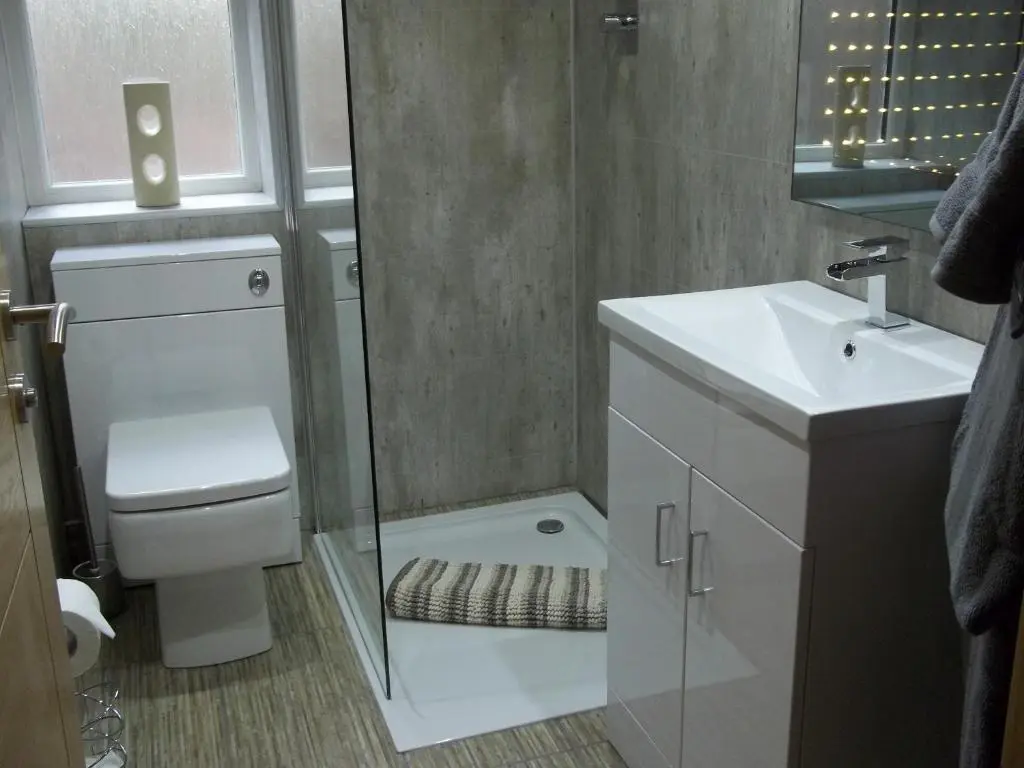 a bathroom with a shower and a toilet and a sink at The Wee Thistle Loch Ness in Drumnadrochit