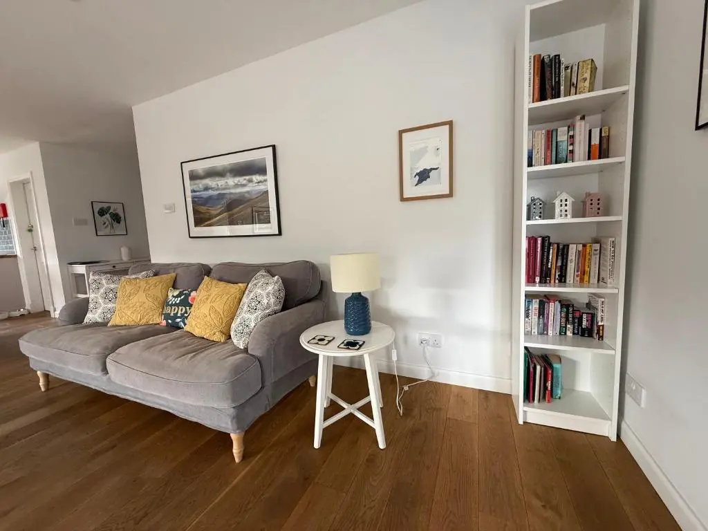 a living room with a couch and a table with a lamp at The Salmon Hut in Aberlour