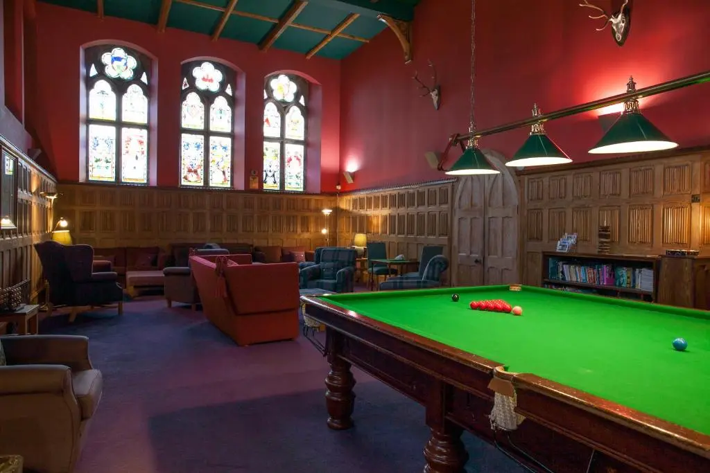 a billiard room with a pool table and stained glass windows at One Bedroom Apartment Highland Club Scotland in Fort Augustus