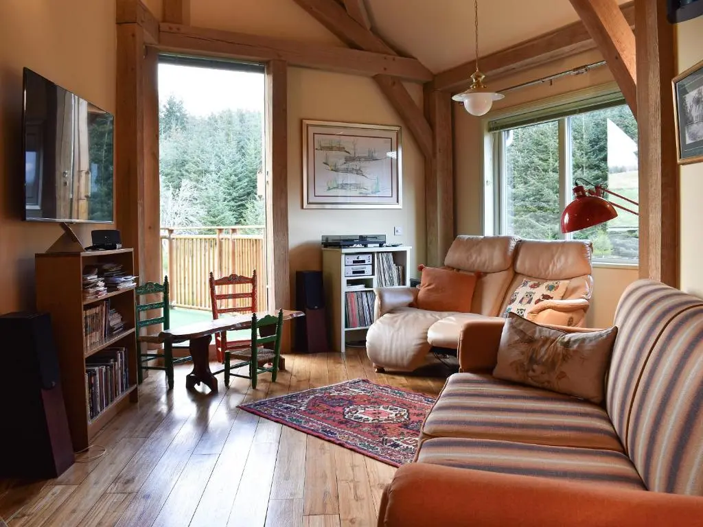 a living room with a couch and a table at Mill Of Burncrook in Glenlivet