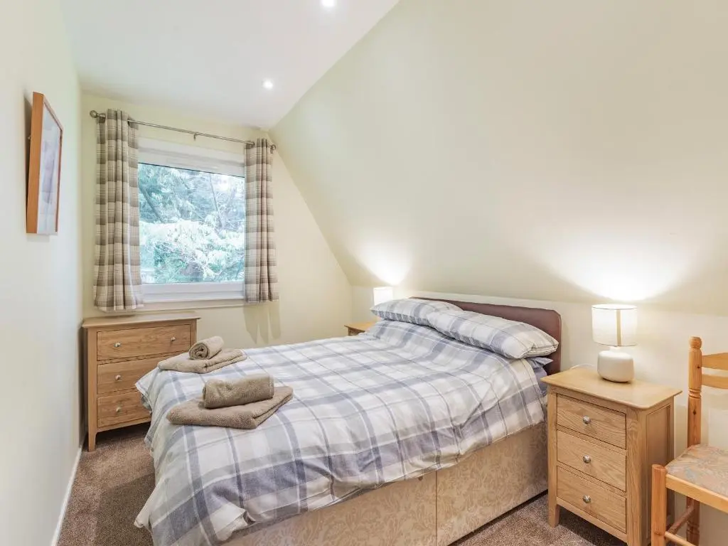 a bedroom with a bed and a window at Gorse Lodge - Uk7050 in Glenurguhart