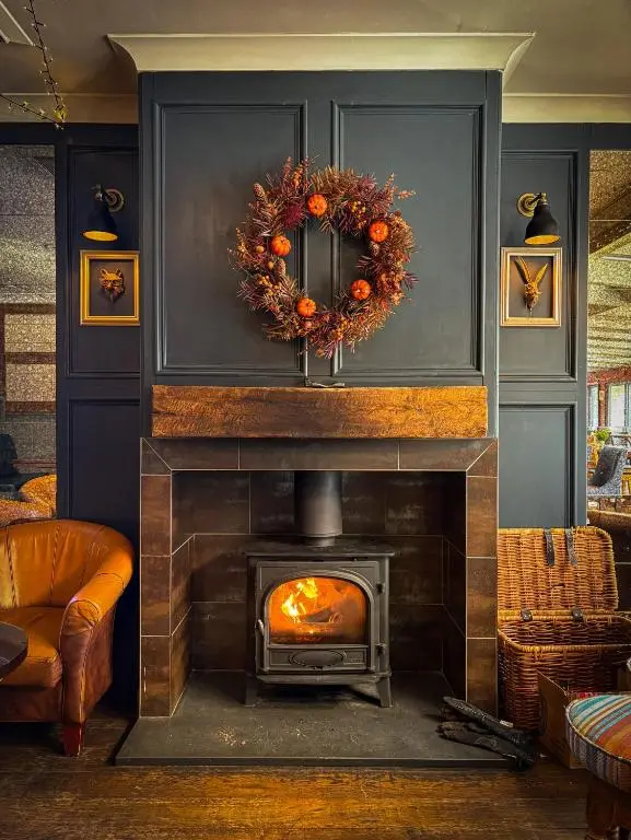 a fireplace with a thanksgiving wreath on top of it at The Balavoulin - Pub with Rooms in Aviemore