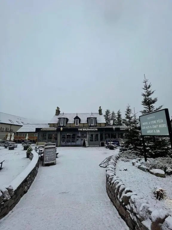 a building with snow on the ground in front of it at The Balavoulin - Pub with Rooms in Aviemore