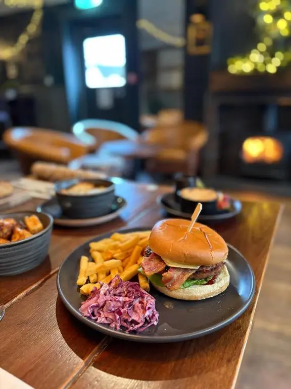 a plate with a sandwich and french fries on a table at The Balavoulin - Pub with Rooms in Aviemore