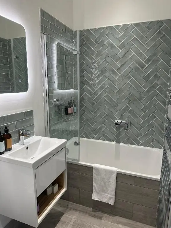 a bathroom with a tub and a sink and a shower at Craigellachie Lodge in Craigellachie