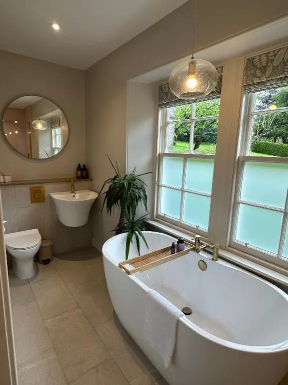 a bathroom with a tub and a toilet and a sink at Craigellachie Lodge in Craigellachie