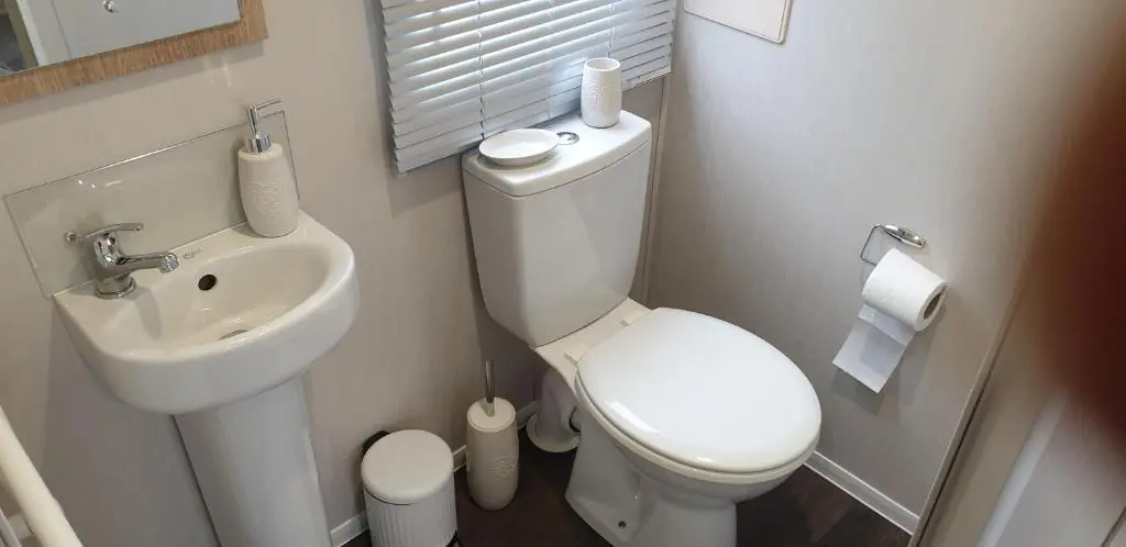a small bathroom with a toilet and a sink at Bonnie Gorm in Boat of Garten
