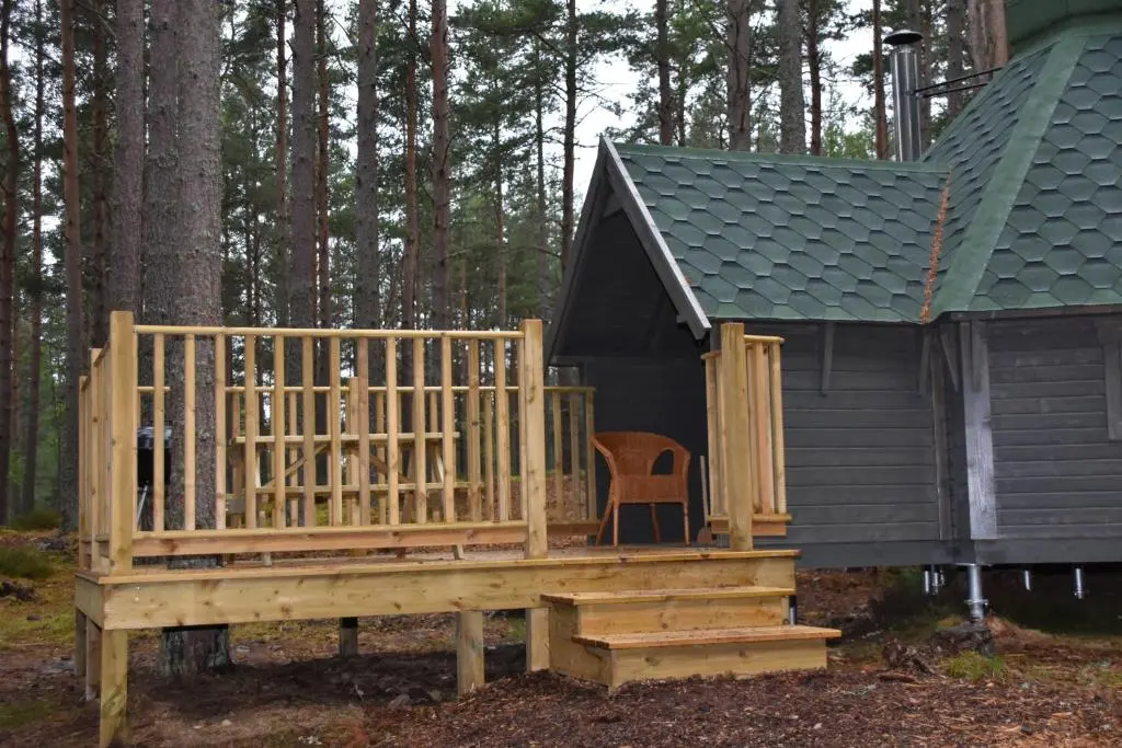 a small cabin with a wooden ramp and a chair at Cairngorm Bothies in Aboyne