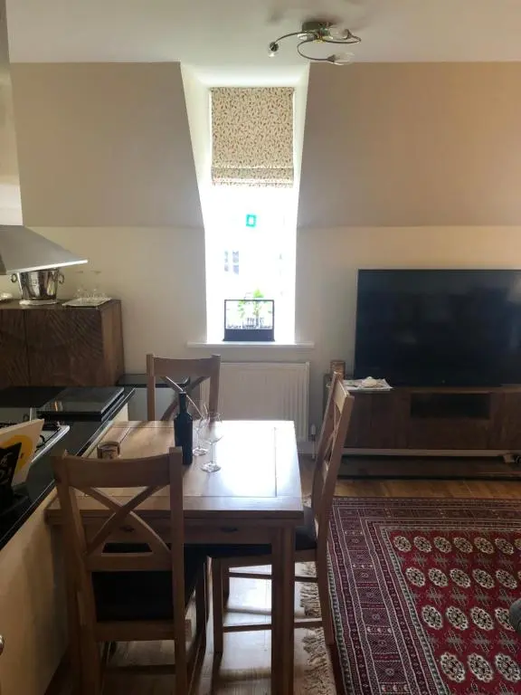 a dining room with a table and a kitchen at Loch Ness Moat House Apartments in Fort Augustus