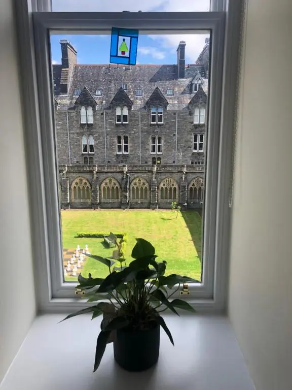 a window with a potted plant in front of a building at Loch Ness Moat House Apartments in Fort Augustus