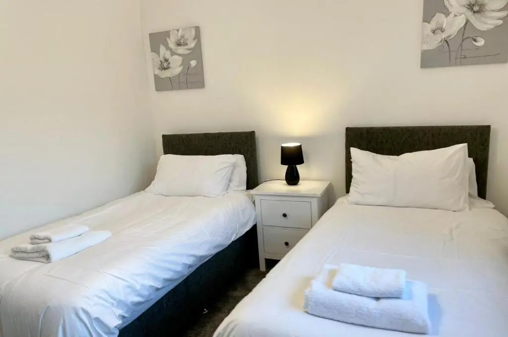 two beds sitting next to each other in a bedroom at Culduthel Cottage in Inverness