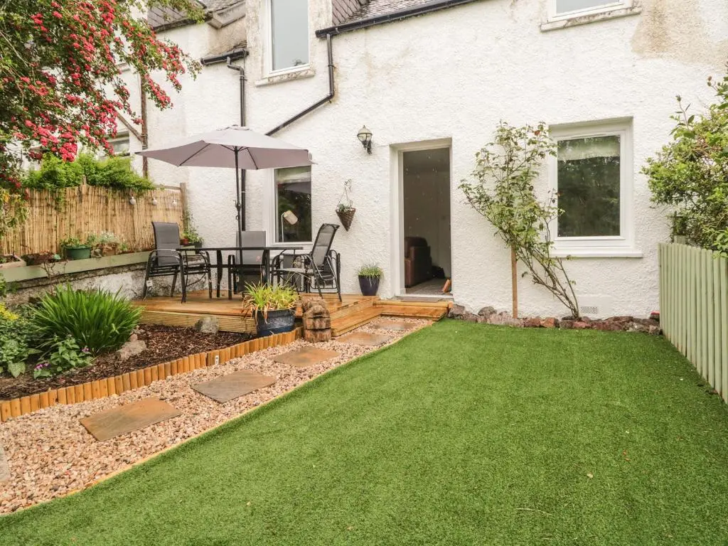 a backyard with a table and an umbrella at Faodail Glenlia in Foyers