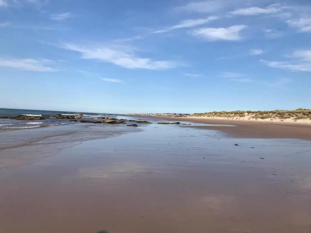 a beach with the ocean and a blue sky at Skerry View - Overlooking the Moray Firth - close to Beaches, Harbour, Shops and Restaurants in Lossiemouth