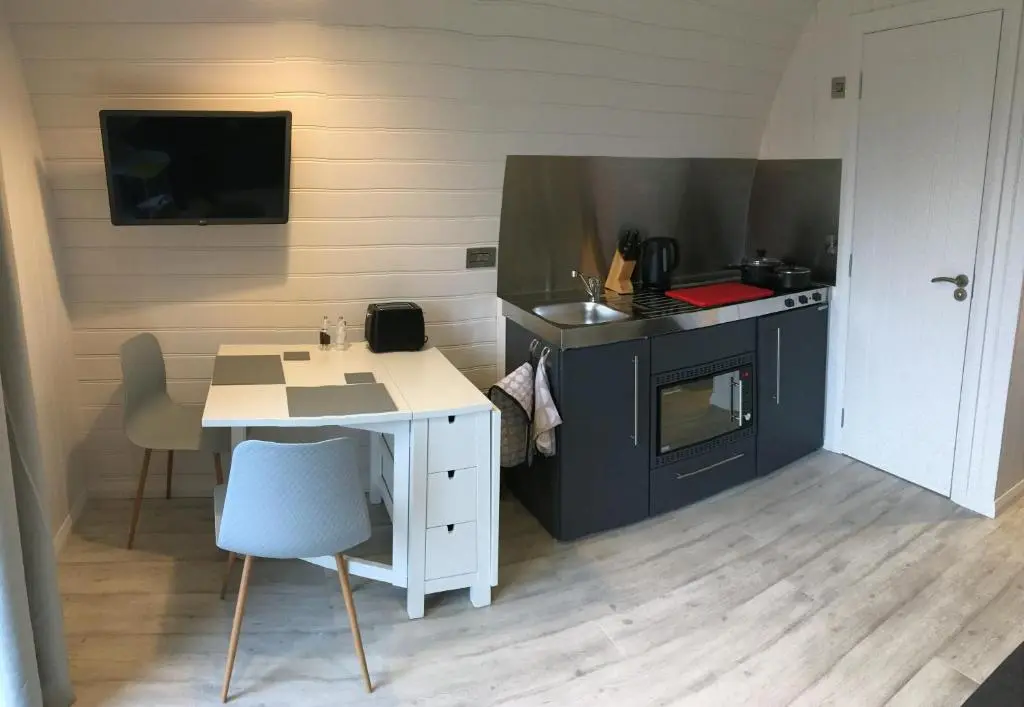 a small kitchen with a table and a stove at Grantown Caravan Park in Grantown on Spey