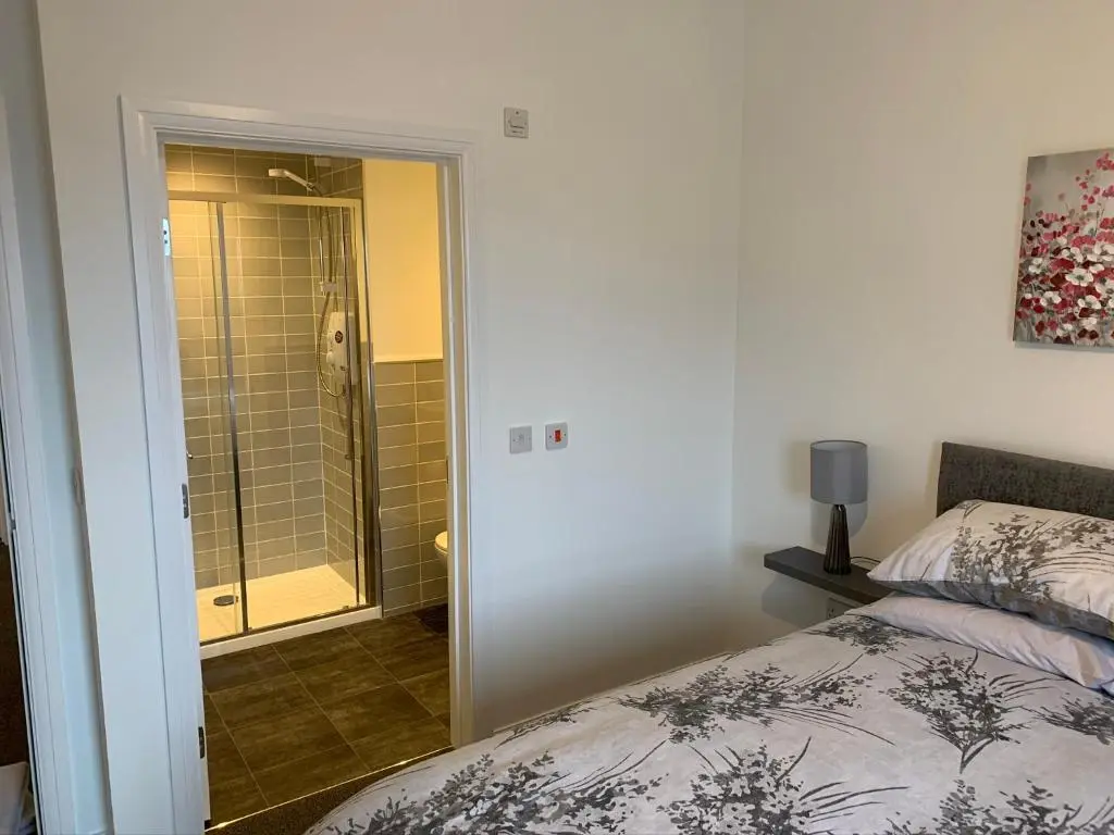 a bedroom with a bed and a shower in a bathroom at Atholl Place View in Inverness