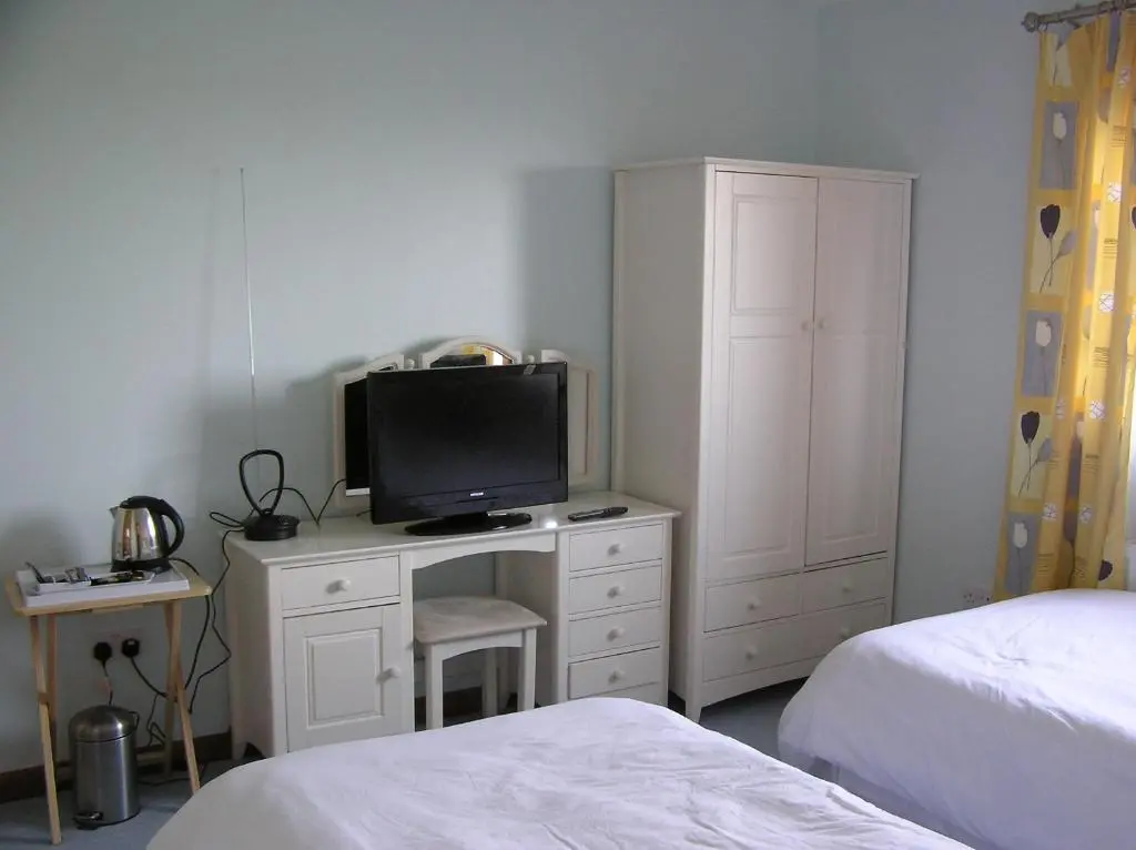 a bedroom with a desk with a television on it at The Antlers in Lybster