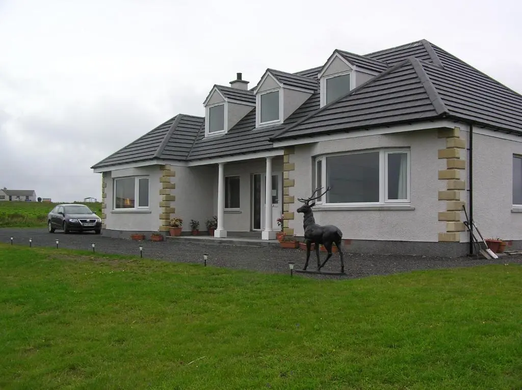 a house with a deer statue in front of it at The Antlers in Lybster