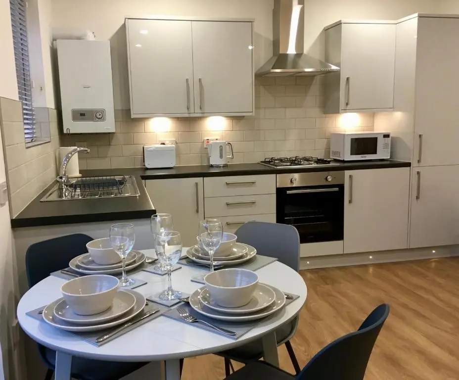 a kitchen with a table with plates and wine glasses at The Tack Room in Inverness