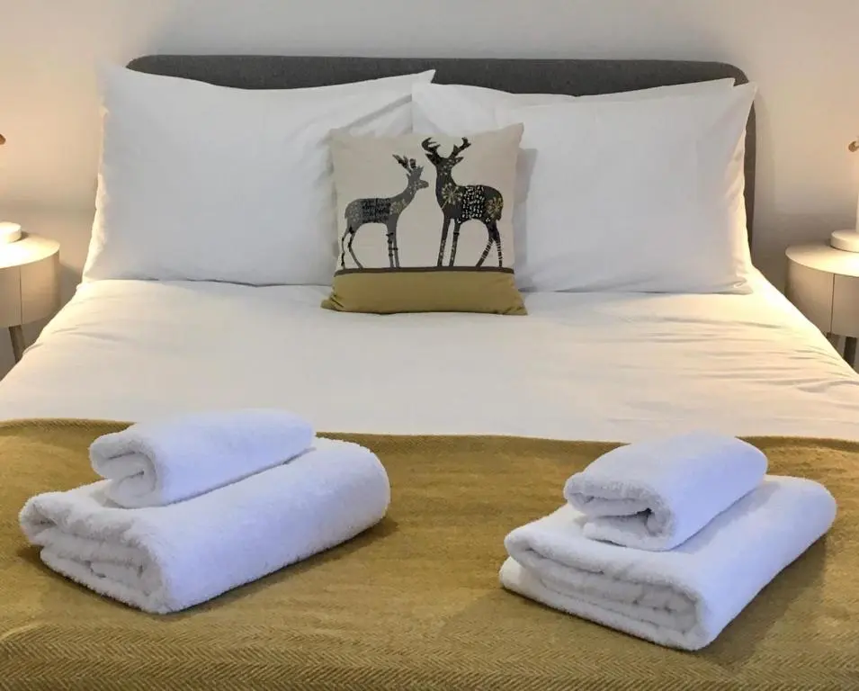 a bed with two towels and two giraffes on it at The Tack Room in Inverness