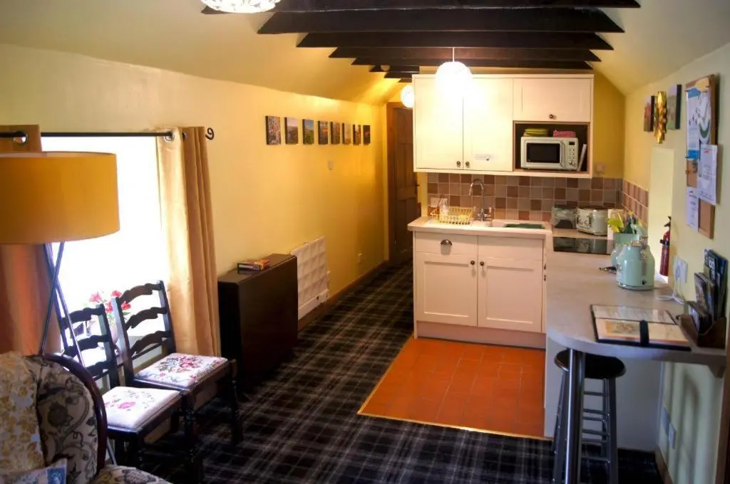 a kitchen with white cabinets and a counter top at Deveron Valley Cottages in Marnoch
